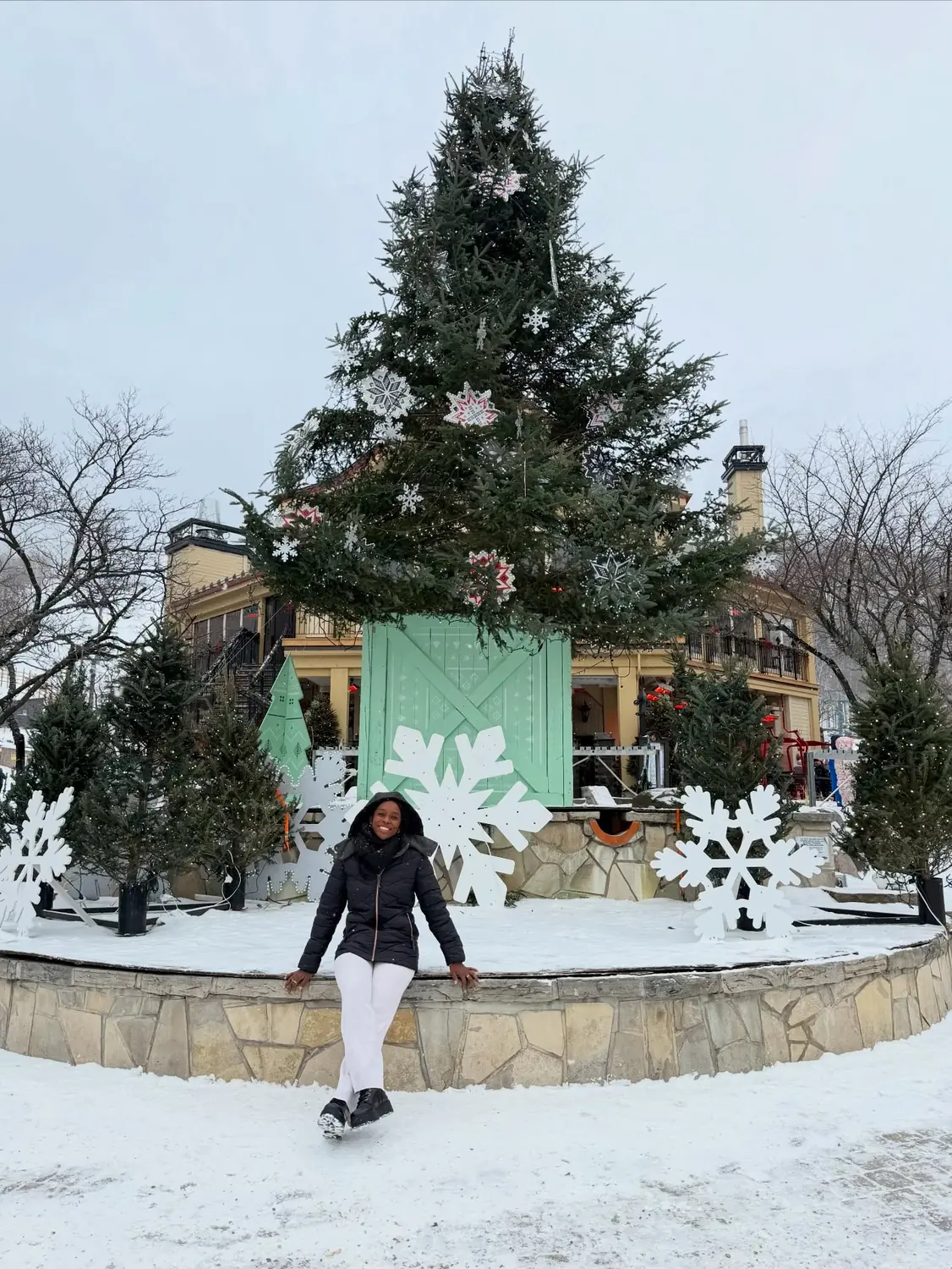 Melody by a giant decorated Christmas tree in the snowy Mont Tremblant village