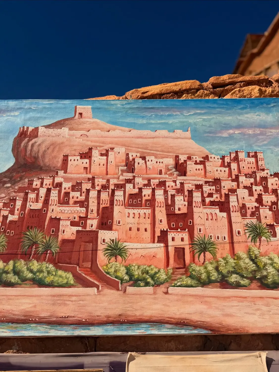 A hand-painted canvas of the Aït Ben Haddou kasbah at a roadside art stall