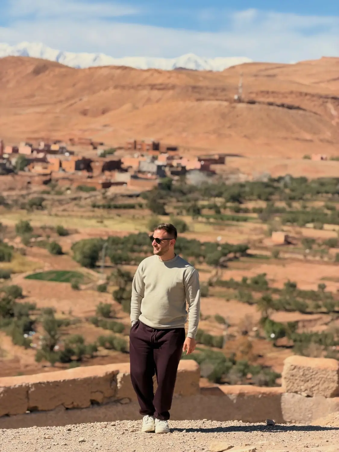 Andrew with a Berber village and the snow-capped High Atlas behind