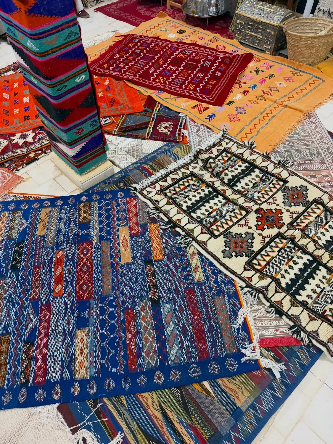Handwoven Berber rugs and kilims spread out across the floor of a carpet cooperative