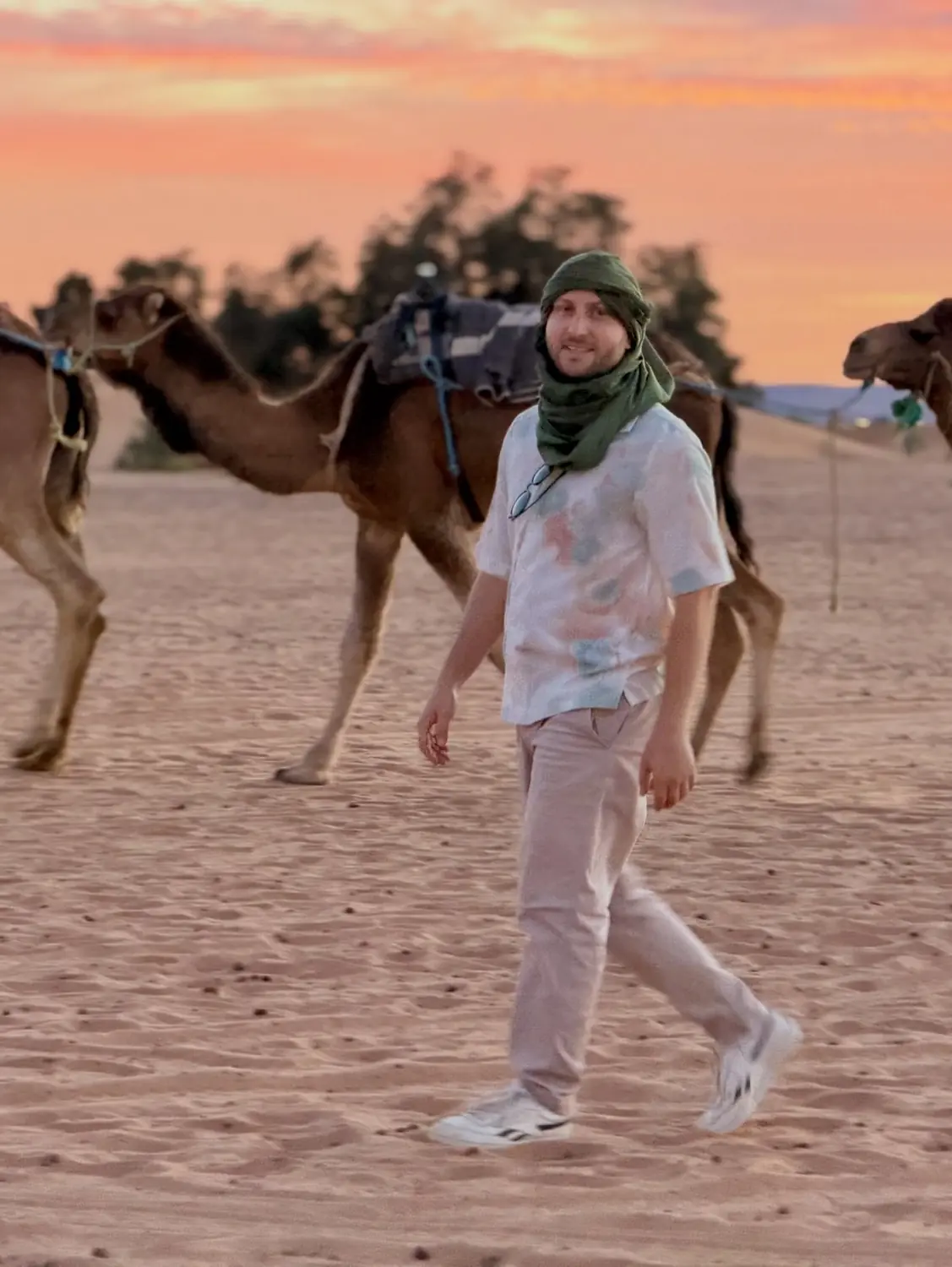 Andrew walking with camels at sunset