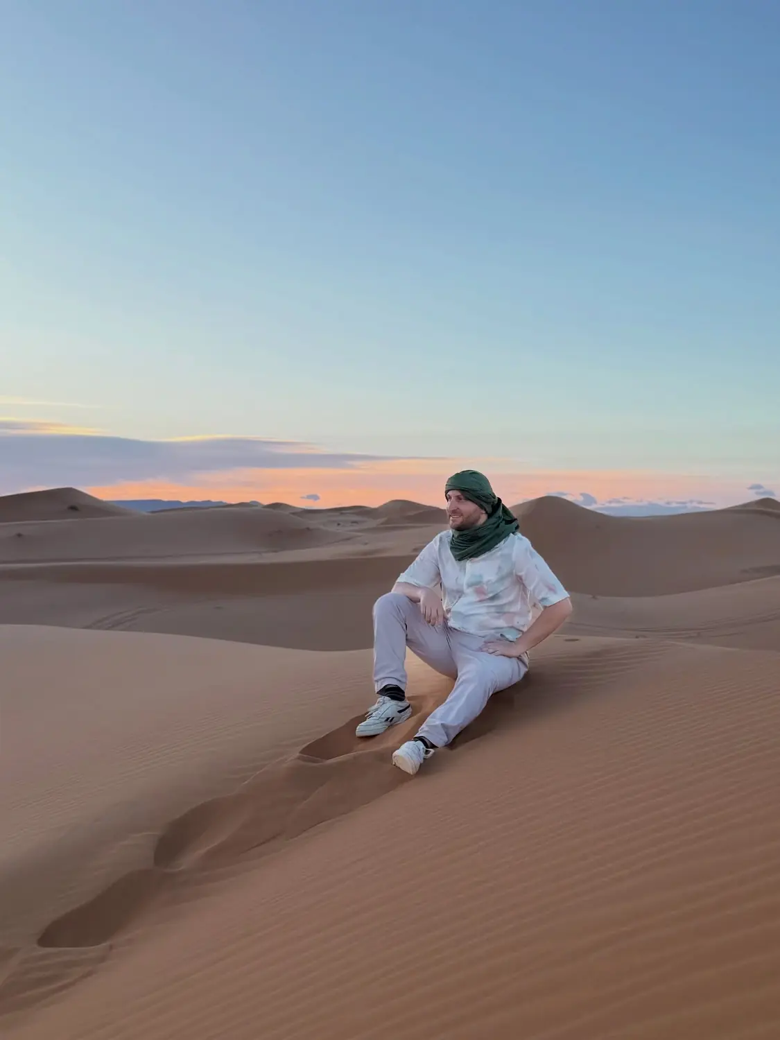 Andrew sitting on a dune ridge at dusk