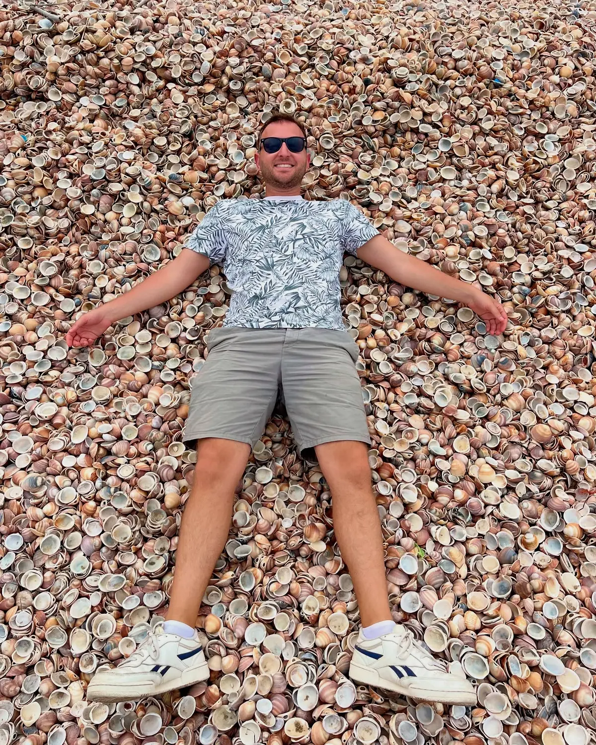 Andrew lying spread out on the Nador seashell beach
