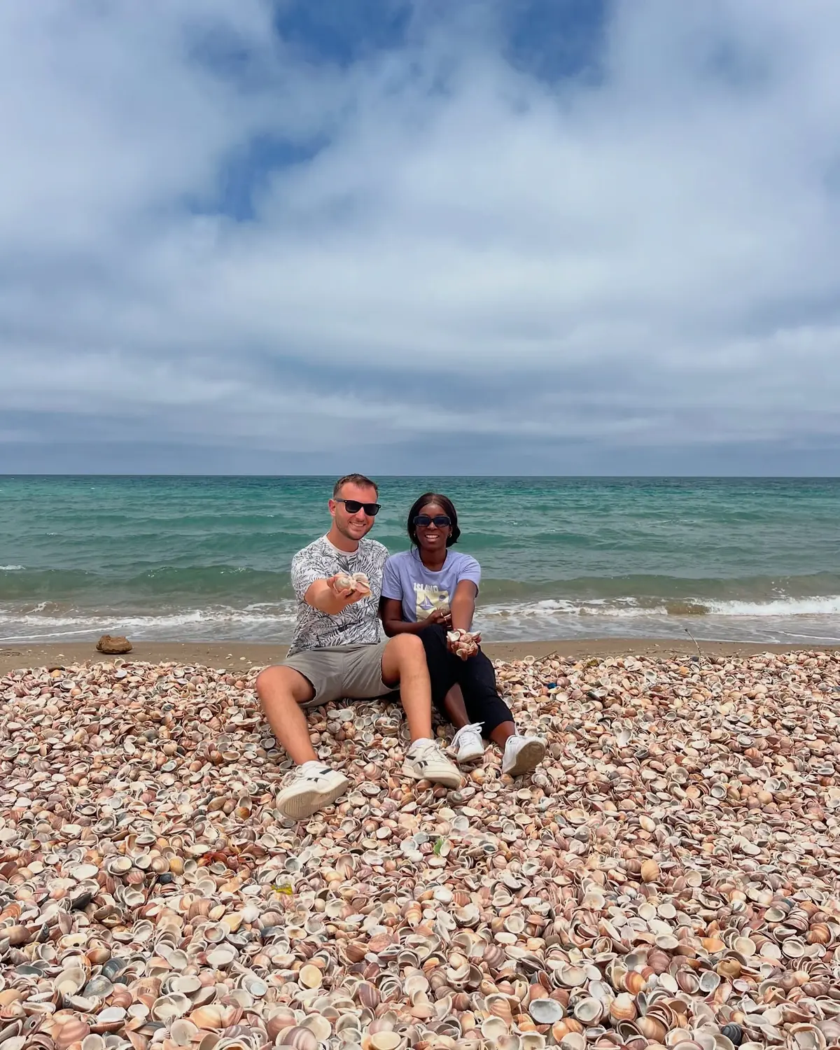 Us sitting on the Nador seashell beach under a moody sky