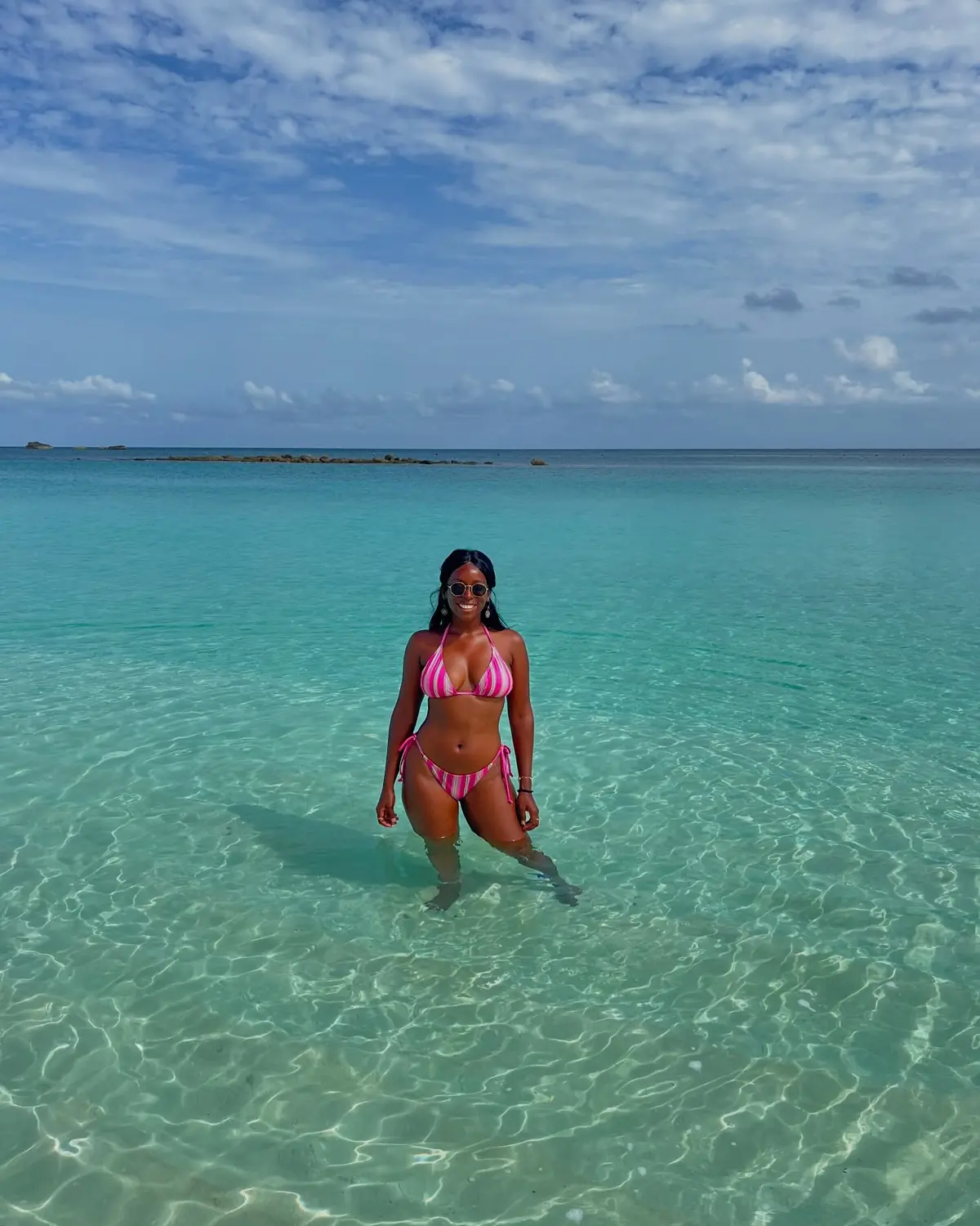 Melody standing waist-deep in glassy, crystal-clear turquoise water