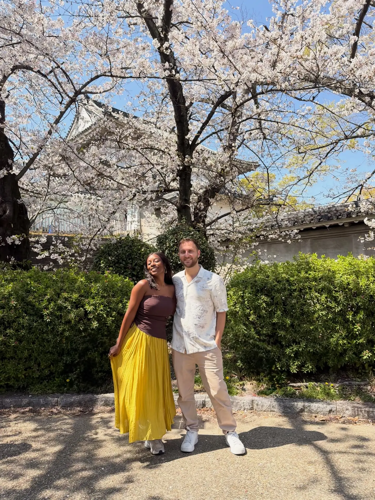 Us under cherry blossoms with Osaka Castle behind