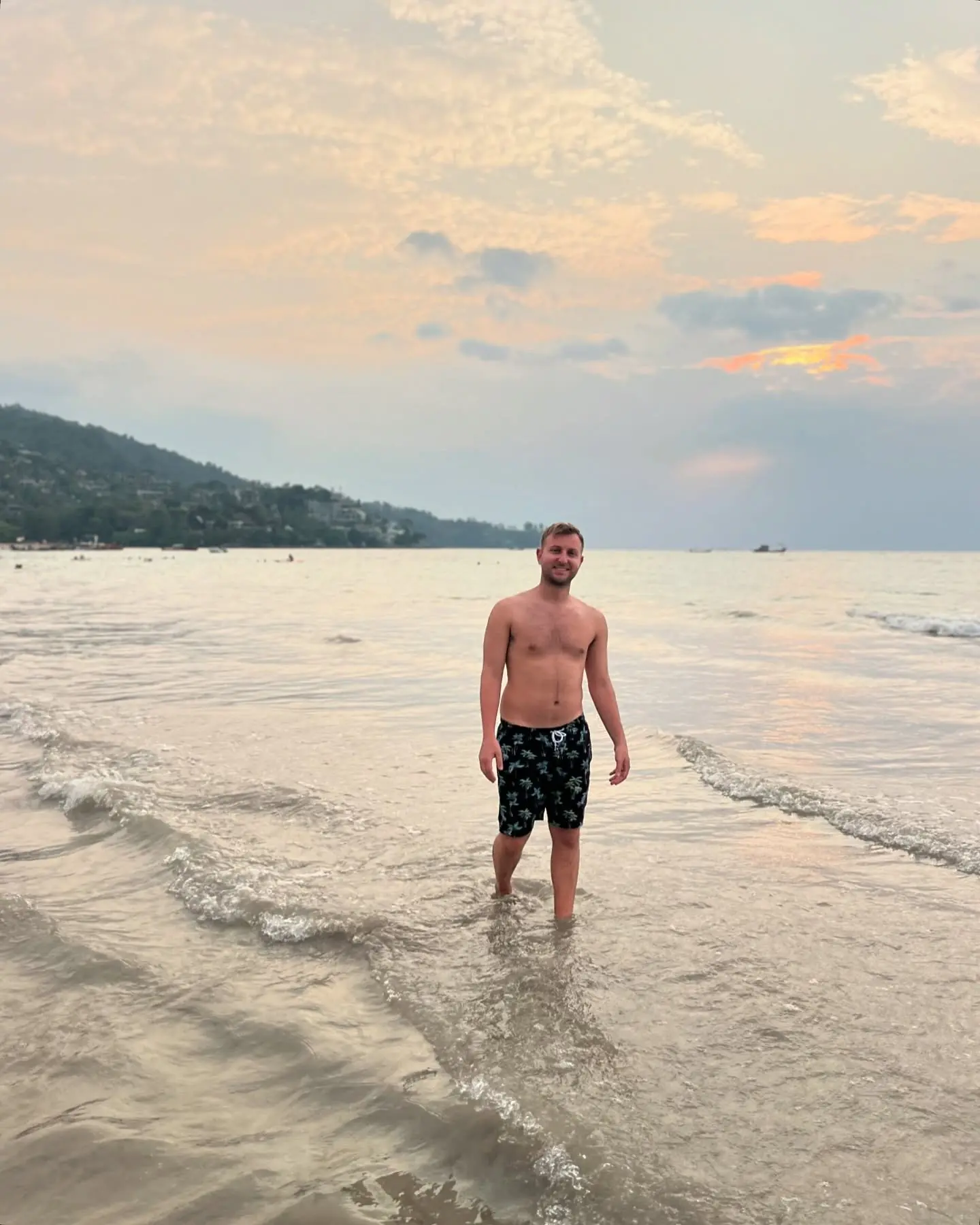 Standing in the shallows at sunset on a Phuket beach