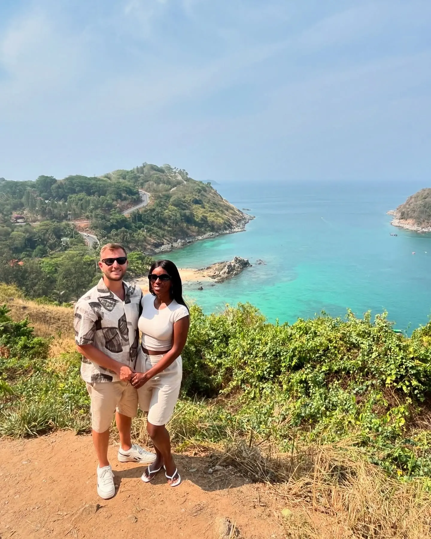 Us at a Phuket clifftop viewpoint over a turquoise bay