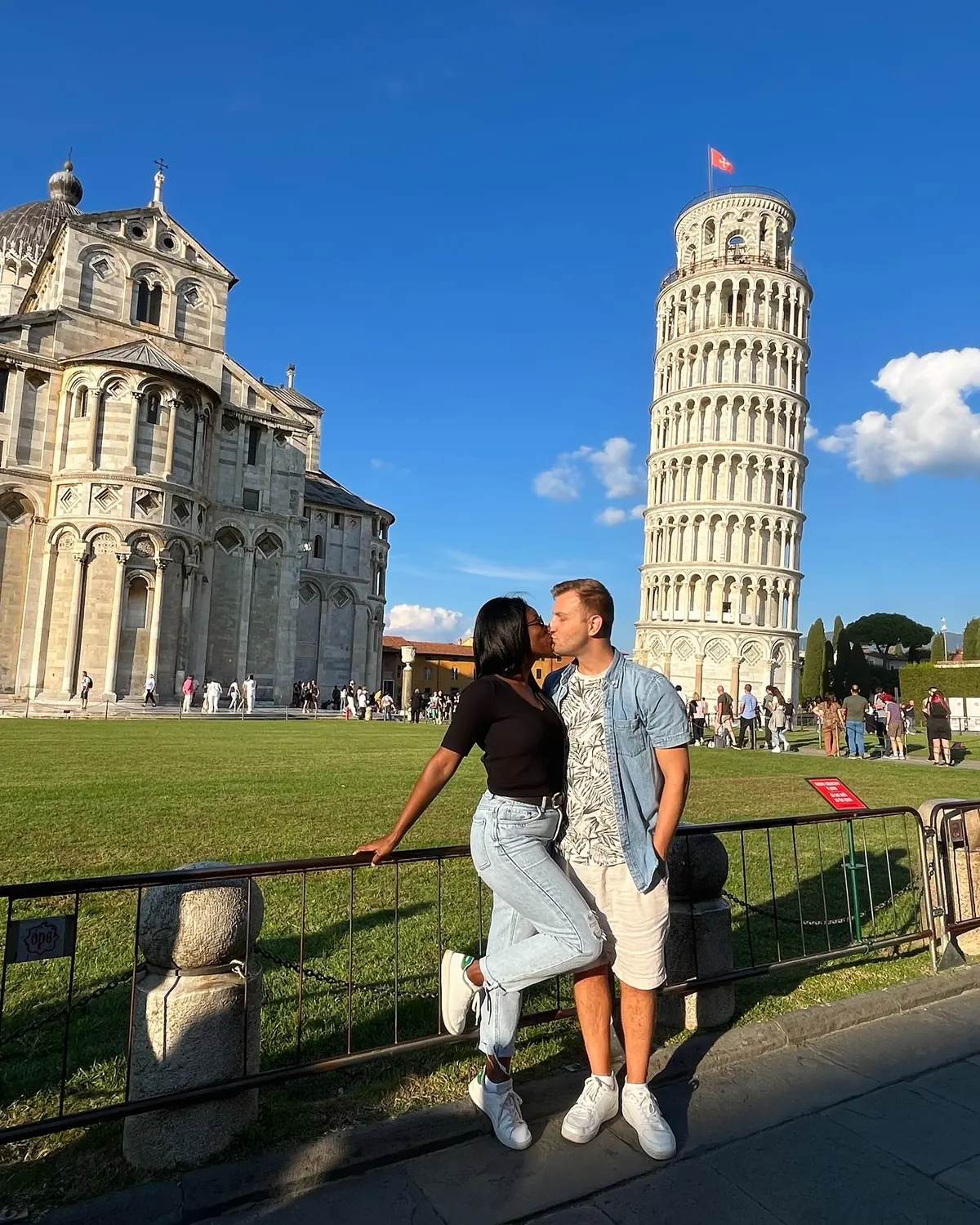 Us sharing a kiss in front of the Leaning Tower and cathedral