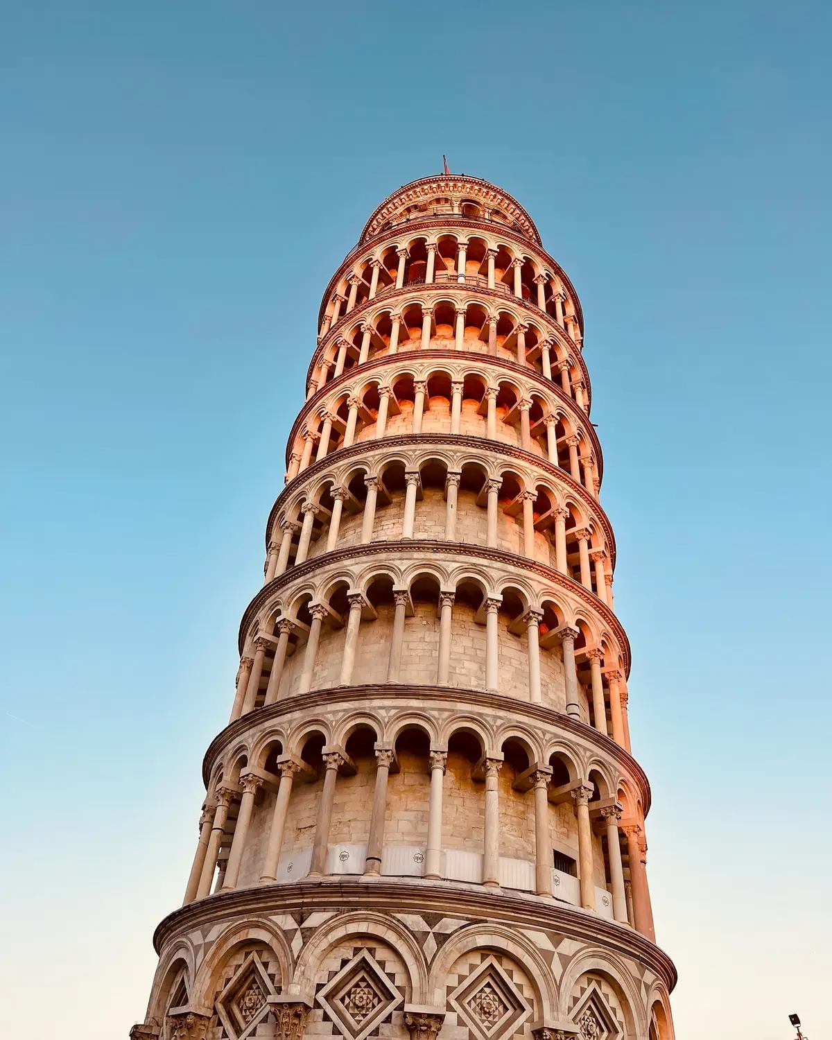 Looking straight up the tilting columns of the Leaning Tower at golden hour