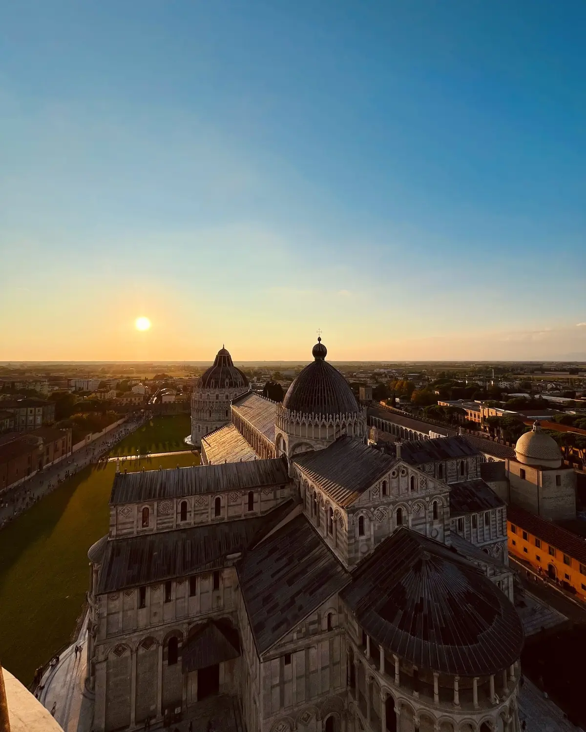 Sunset view from the top of the Leaning Tower over the cathedral and Tuscan plain
