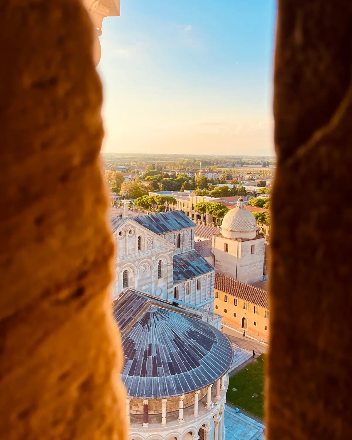 View framed through a tower window down onto the Pisa cathedral rooftops