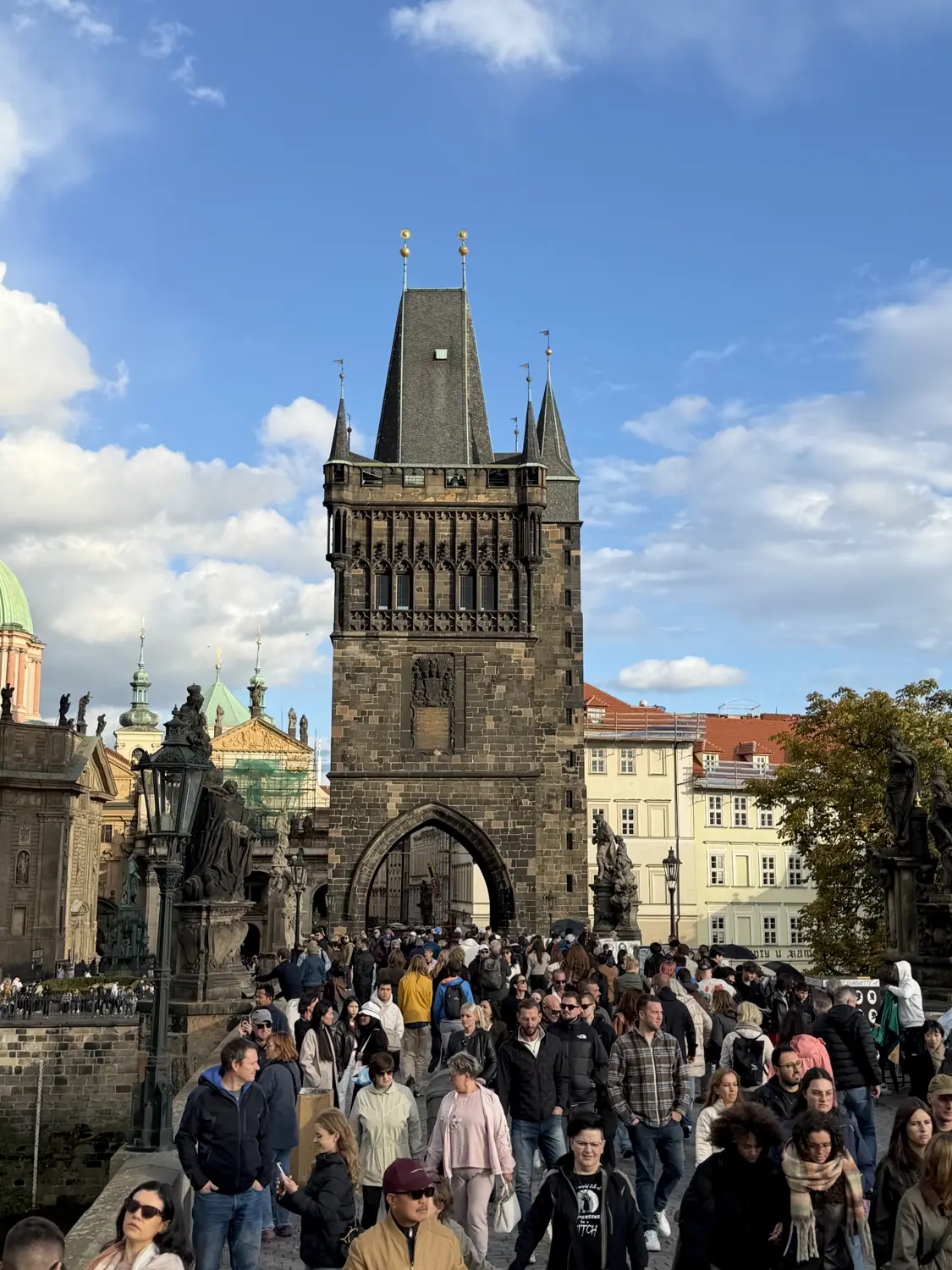 The Gothic bridge tower rising above the crowds on Charles Bridge