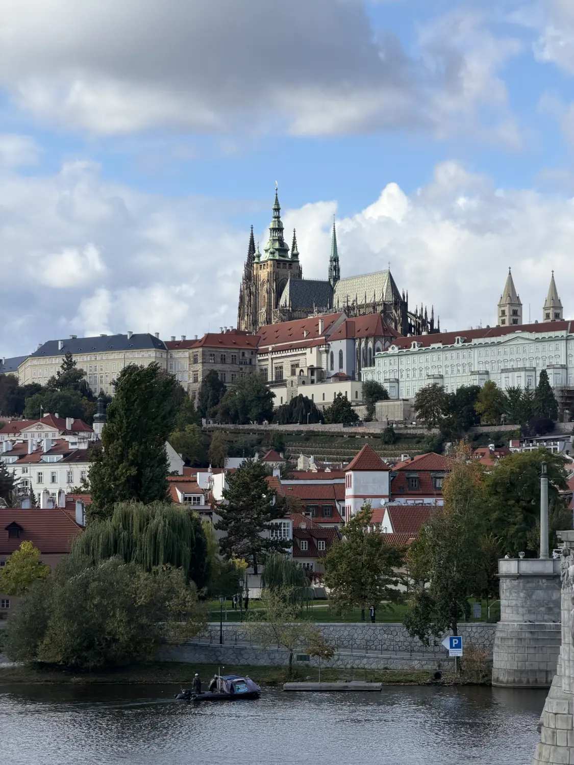 Prague Castle above the red rooftops seen from across the river