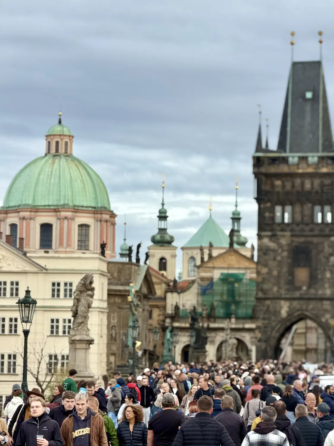 The Old Town Bridge Tower and a green-domed church at the entrance to Charles Bridge