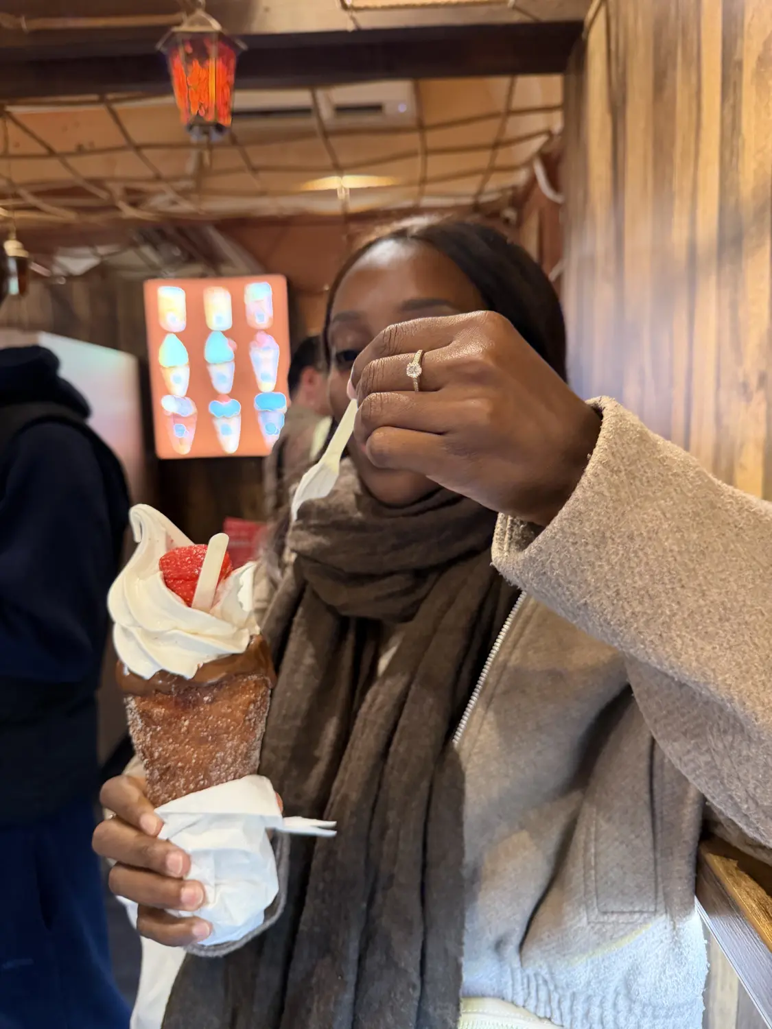 Melody biting into a chimney cake filled with ice cream