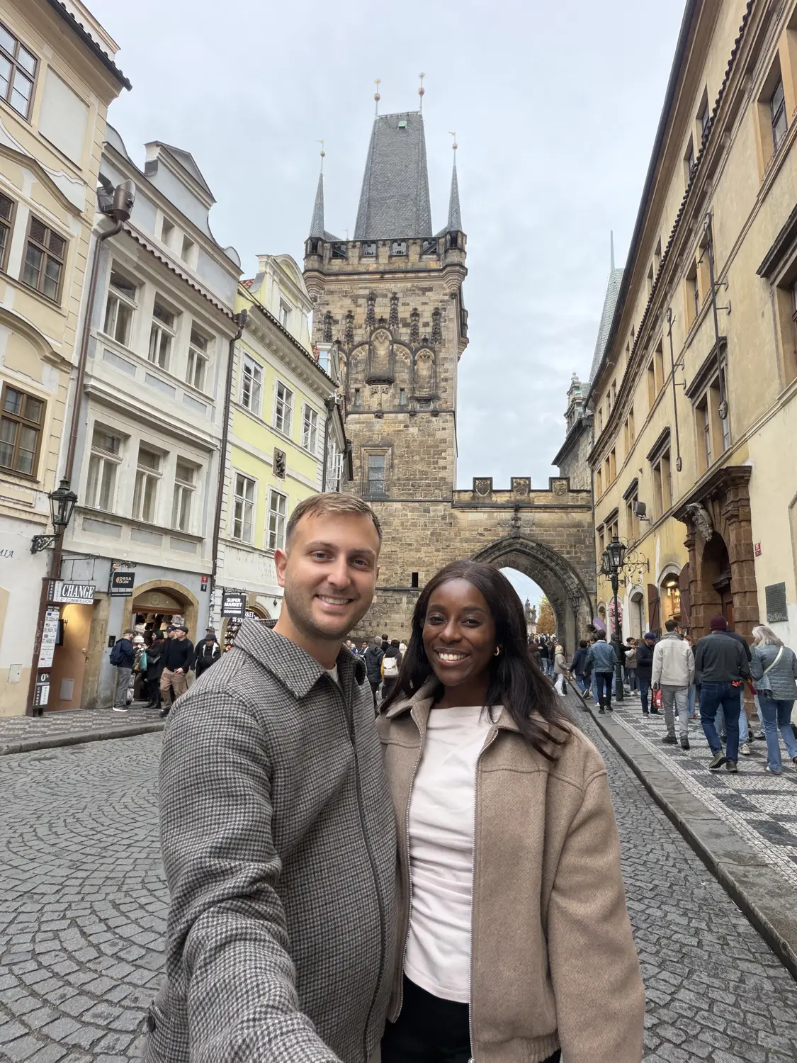 Us on a cobbled street with a Gothic tower behind us