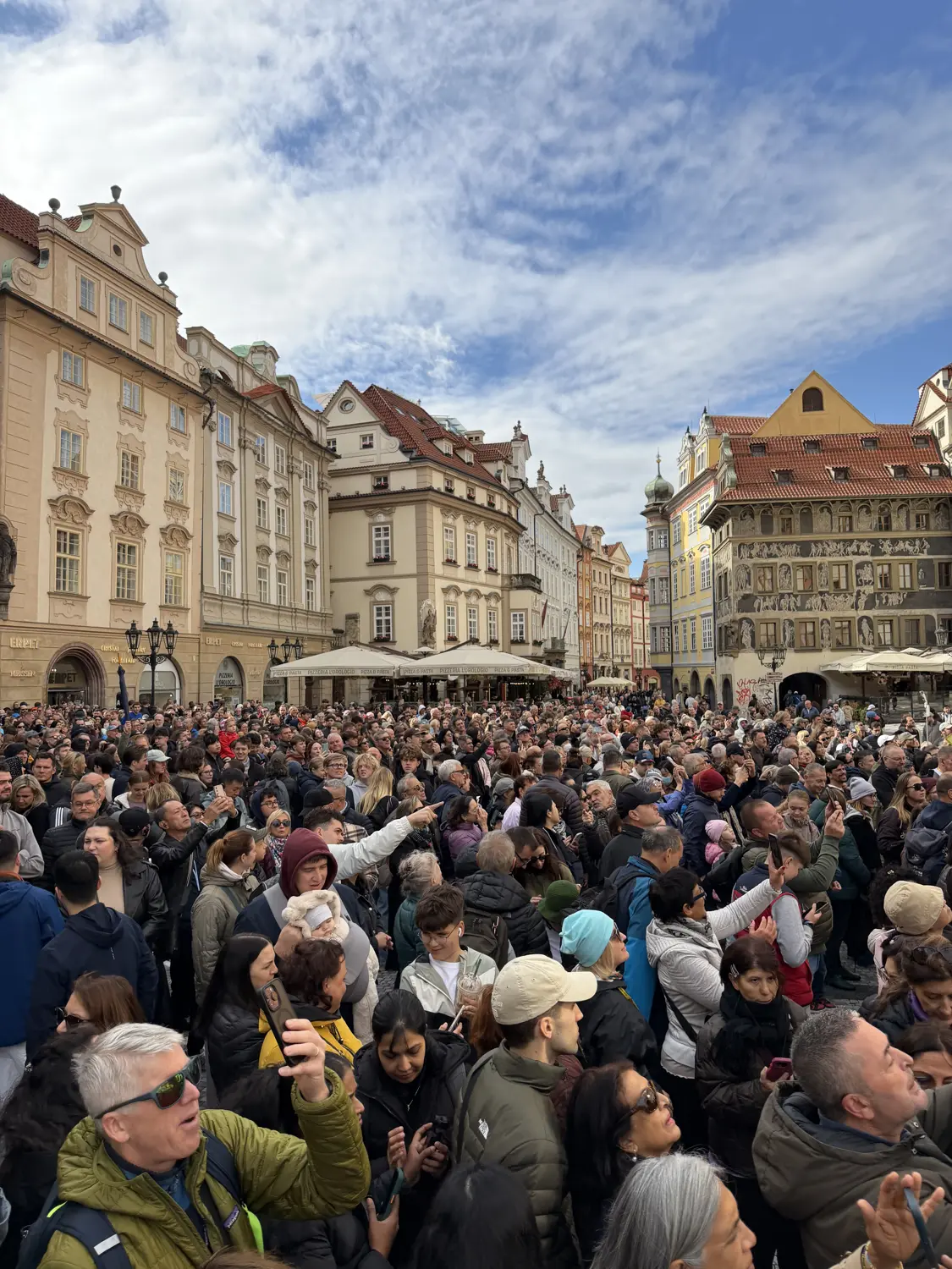 The packed Old Town Square in front of colourful baroque facades