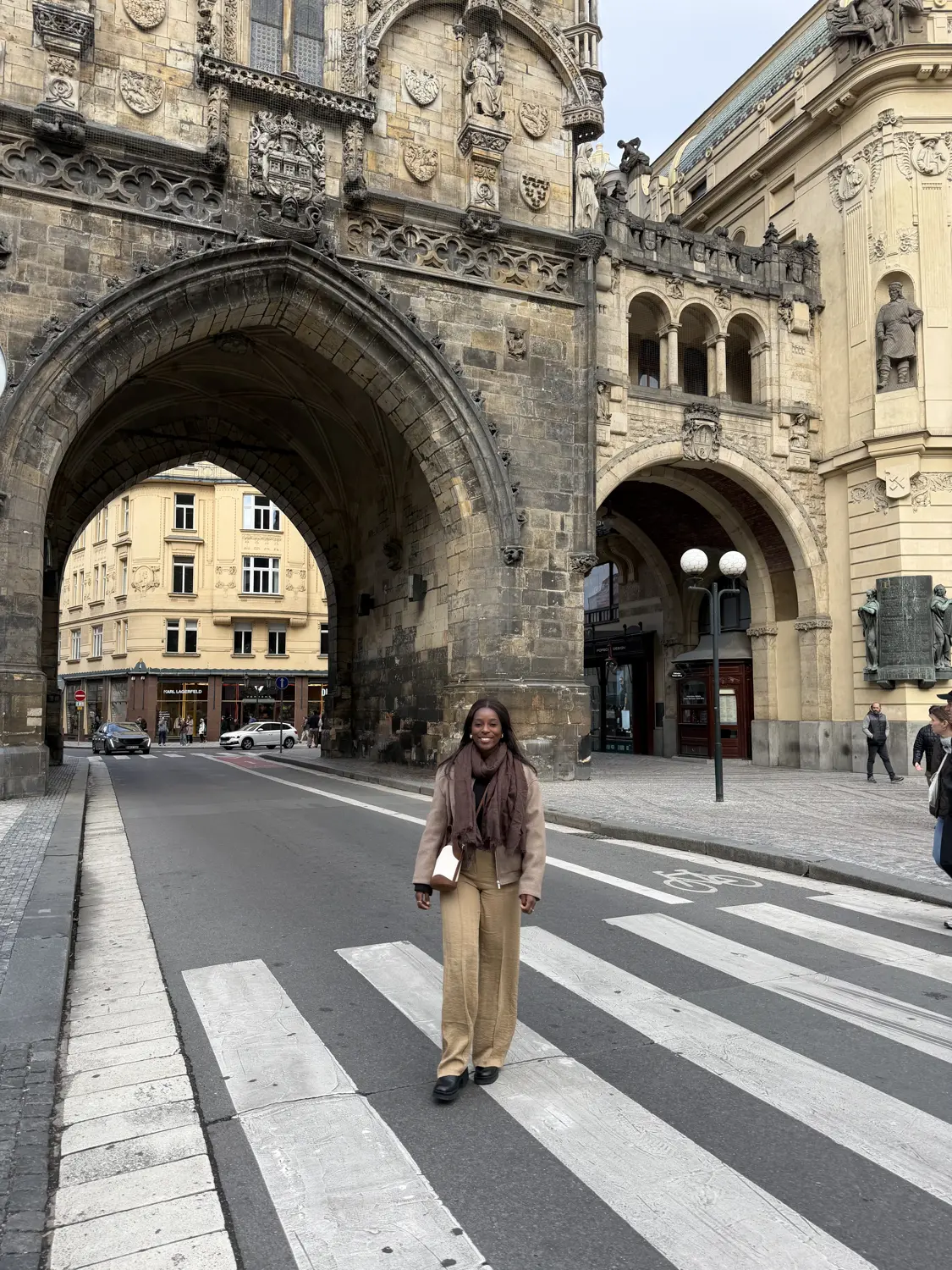 Melody standing under the archway of the Powder Tower gate