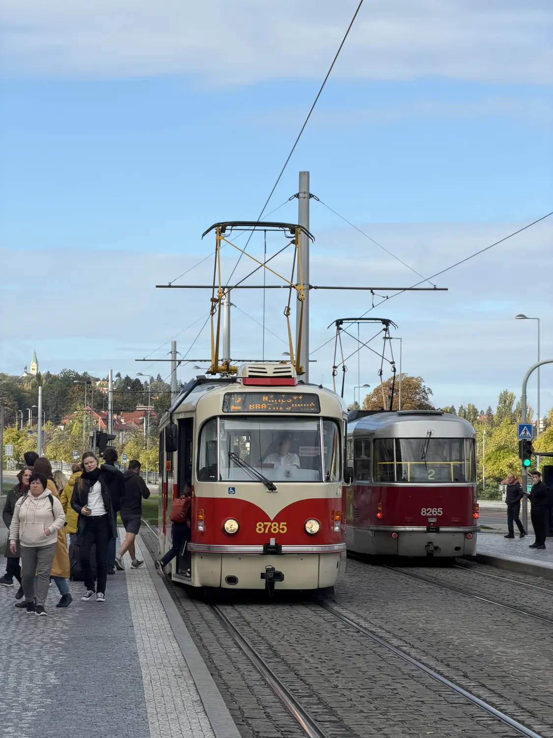Two classic red Prague trams on a city street