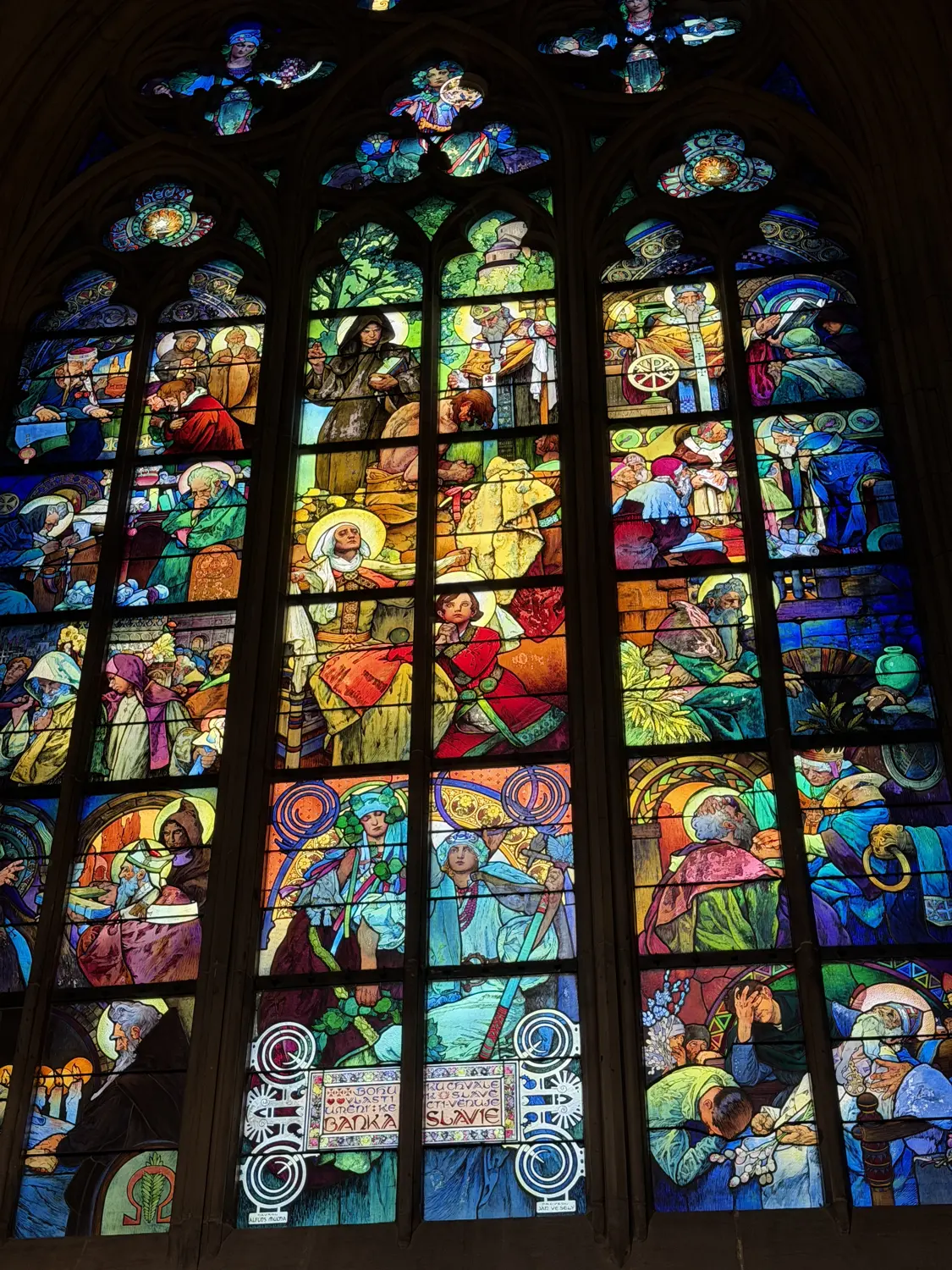 A brightly coloured stained-glass window inside St Vitus Cathedral