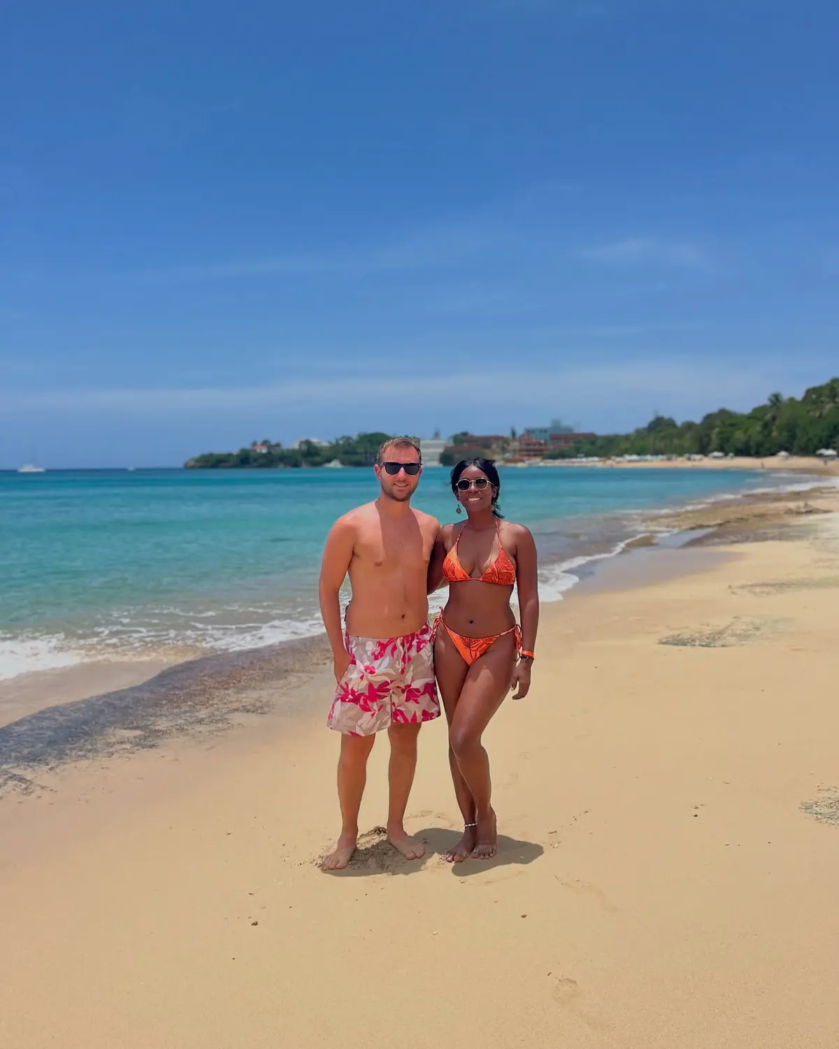 Us on the beach at Sosúa with turquoise water and a green headland behind, Puerto Plata