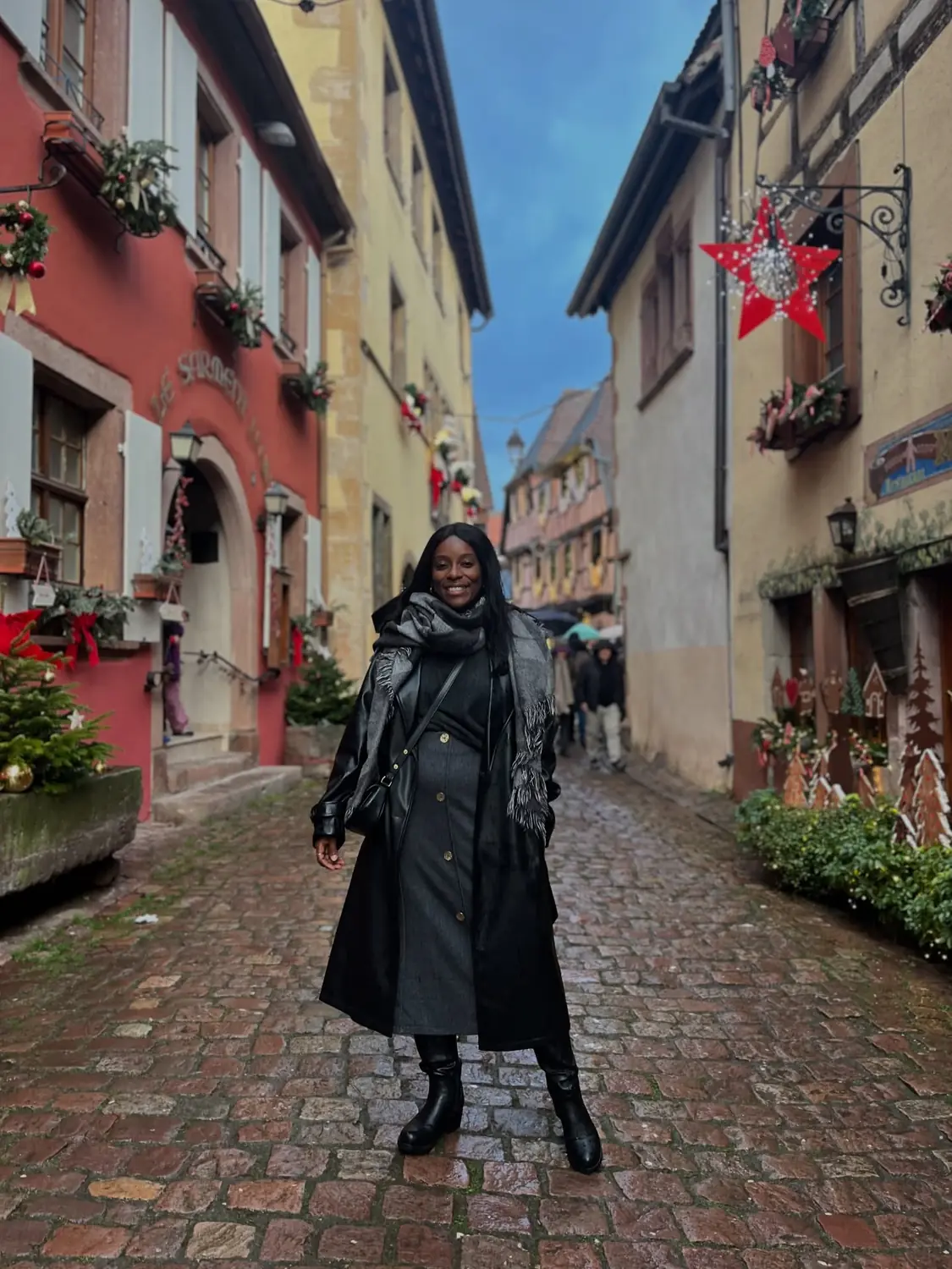 Melody in a quiet cobbled Riquewihr lane with a big red star decoration and colourful houses