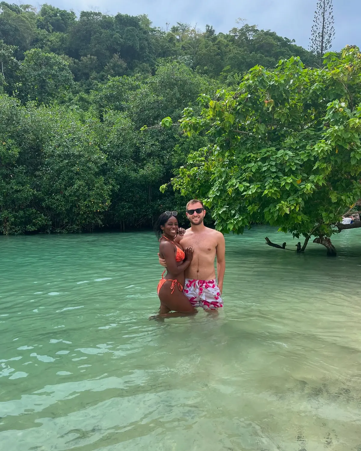 Us standing in a clear green mangrove lagoon backed by dense jungle in Samaná