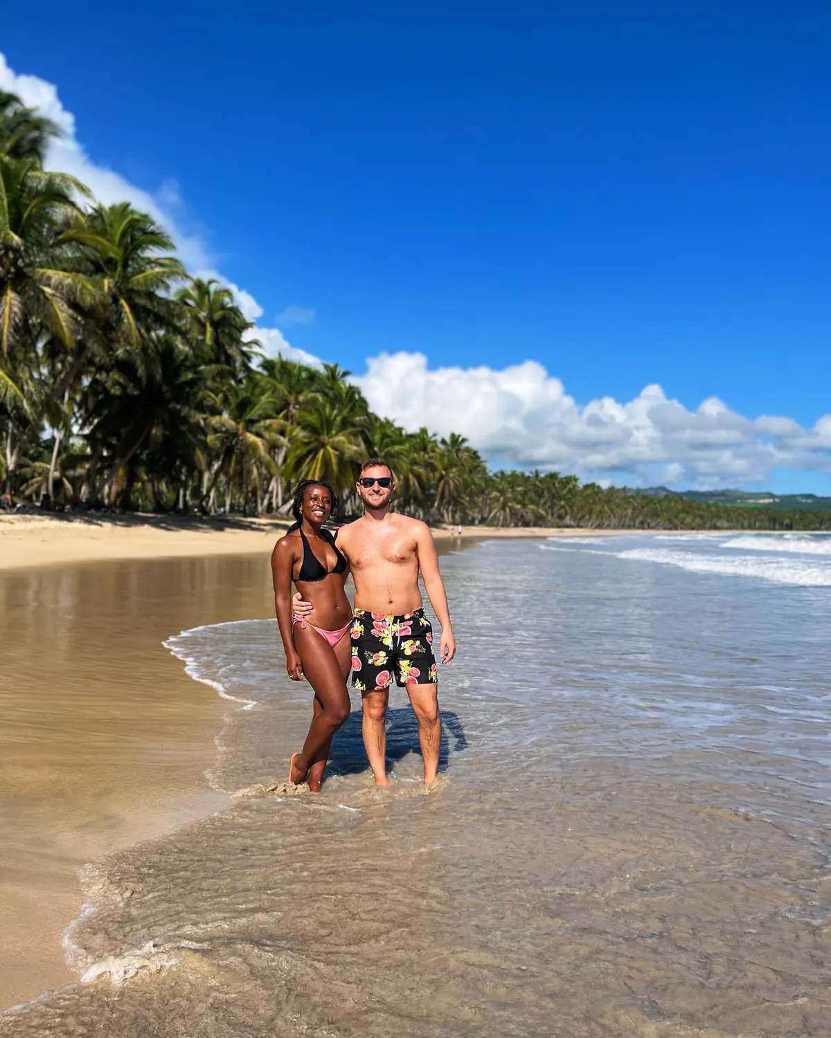 Us on a wild, palm-lined beach in Samaná, the Dominican Republic