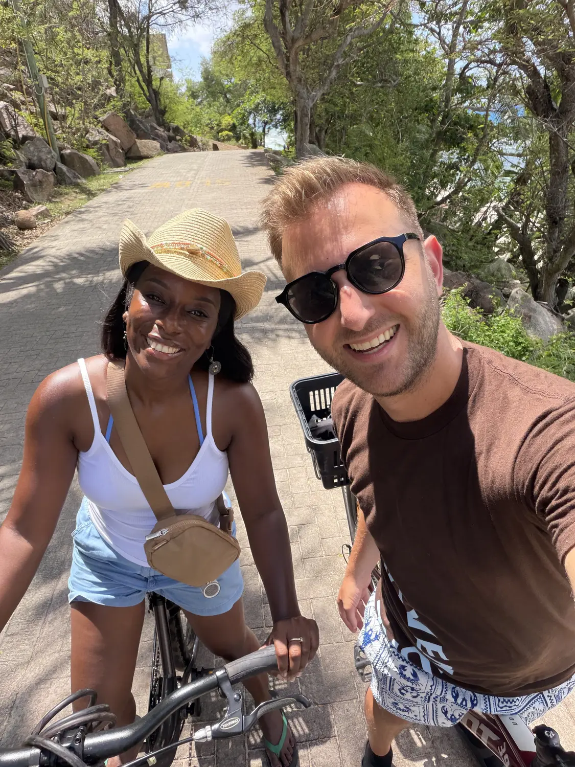 Us taking a selfie on our rented bikes on a shady La Digue lane