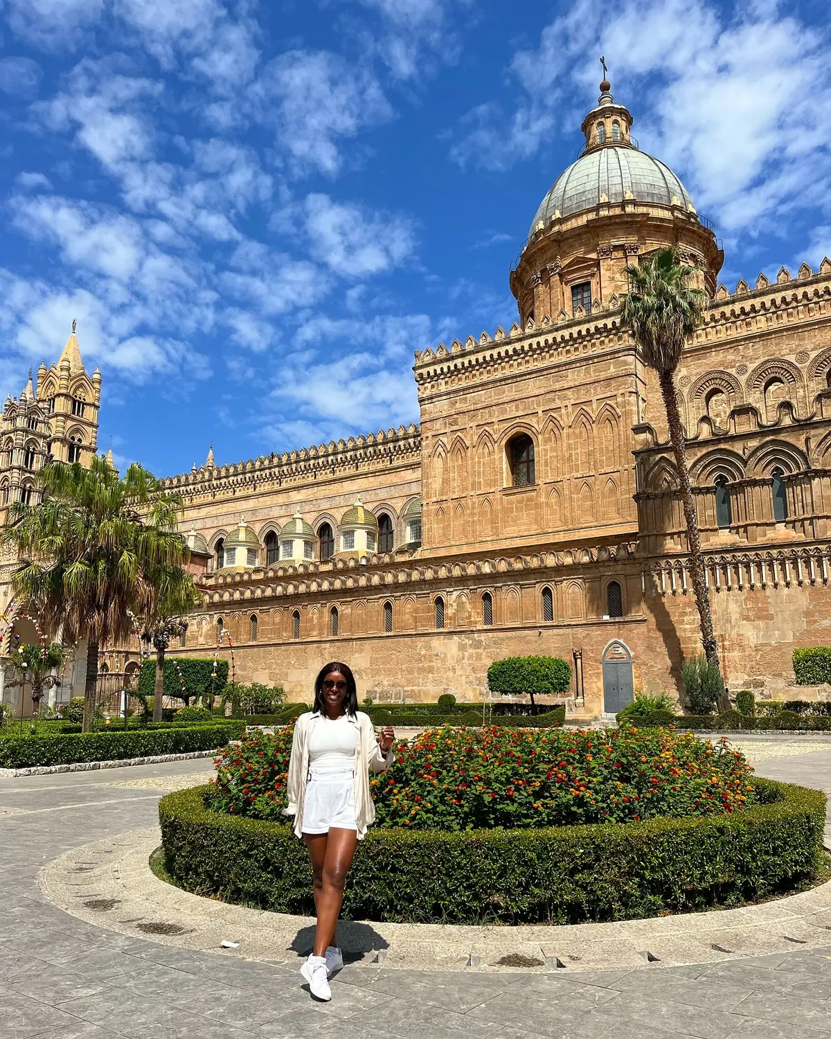 Melody in white in front of the full facade of Palermo Cathedral