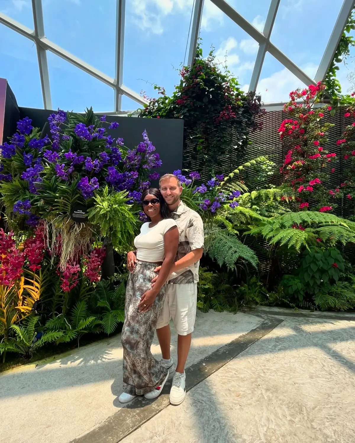 Us among vivid purple and red orchids inside the Flower Dome conservatory