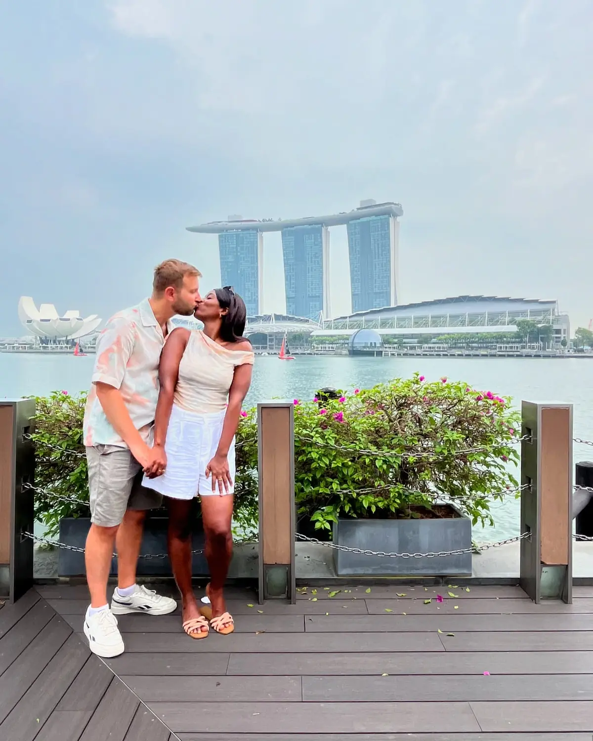 Us sharing a kiss on the waterfront promenade with Marina Bay Sands behind