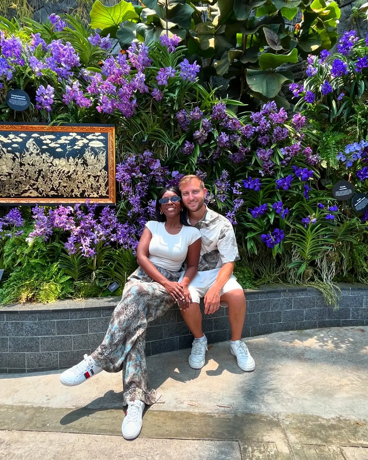 Us in front of a wall of purple orchids