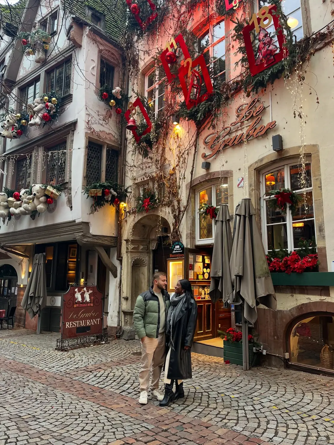 Us outside Le Gruber restaurant in Strasbourg, its facade covered in an advent-calendar of decorations