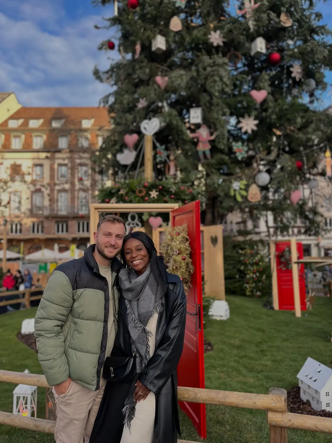 Us in front of the giant Christmas tree with a red door installation at Place Kléber, Strasbourg