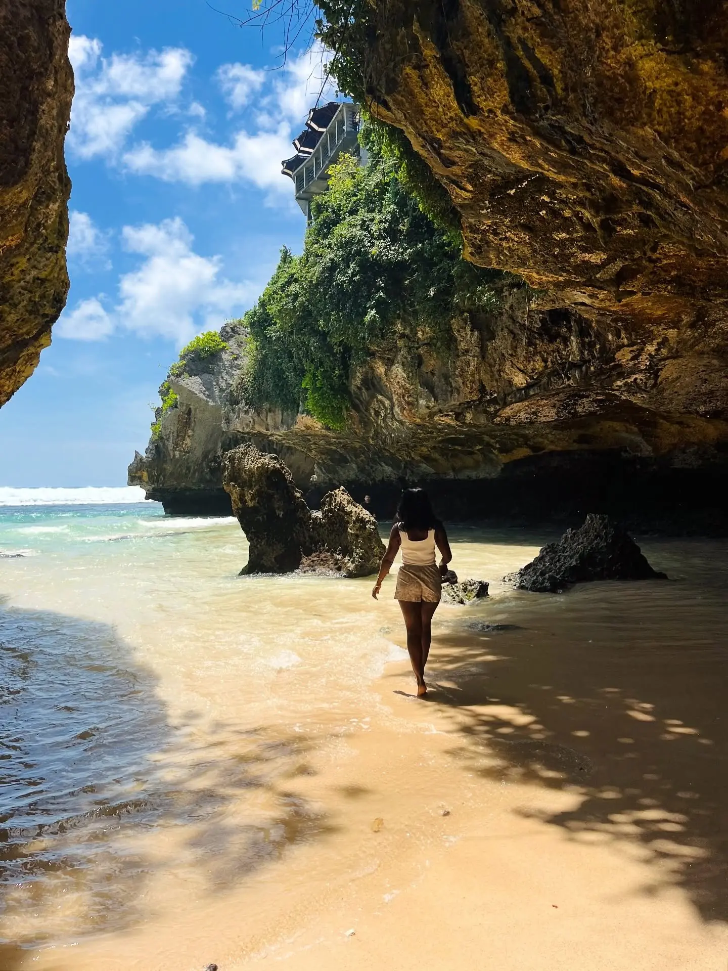 Walking a hidden cave-framed cove beach at Uluwatu