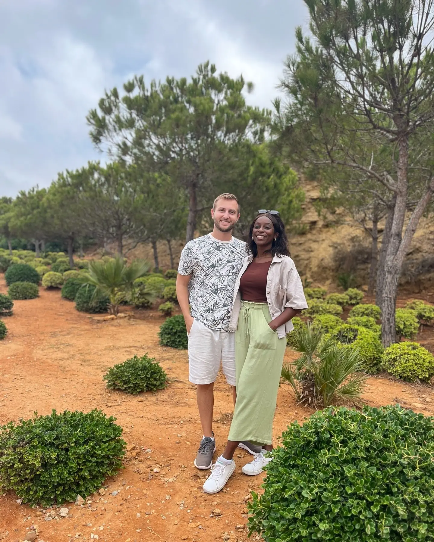 Us in a green garden of parasol pines and clipped boxwood topiary in Tangier