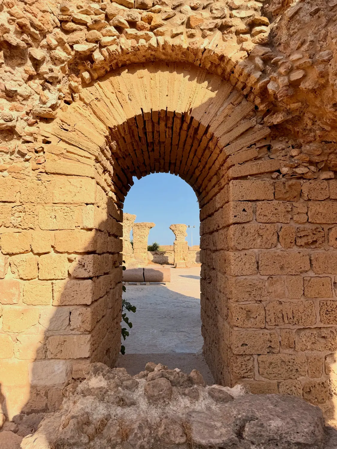 A honey-coloured brick arch among the ancient ruins of Carthage