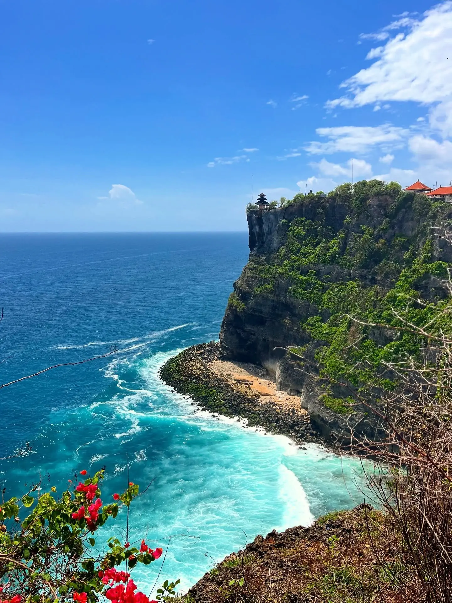 Uluwatu Temple perched on the sea cliff with turquoise surf below